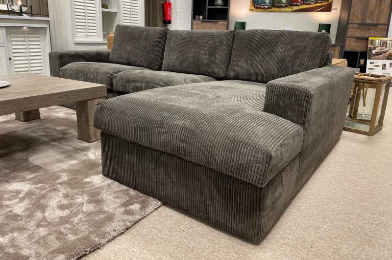 Loungebank Leiden met longchair in een moderne woonkamer met houten salontafel en lichte muren.